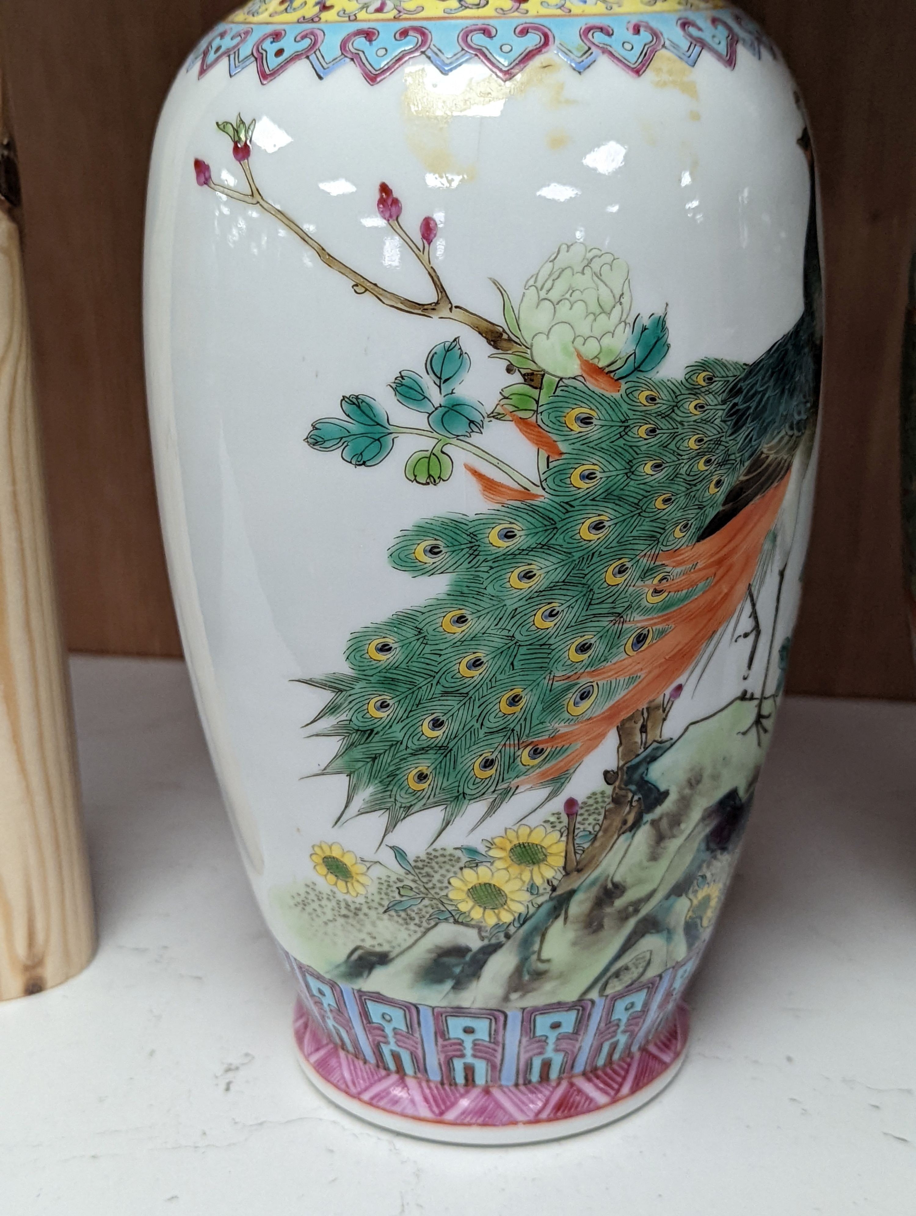 A pair of Chinese famille rose vases decorated with peacocks, 31cm